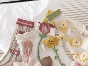Detailed view of floral mesh socks with tulip and daisy embroidery in pastel colors
