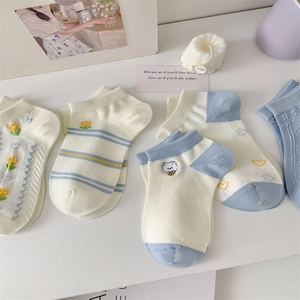 Close-up of assorted blue embroidered cotton socks with bear and floral patterns