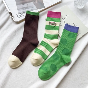 Detail view of cotton crew socks with Good Luck embroidery, stripes and polka dot patterns