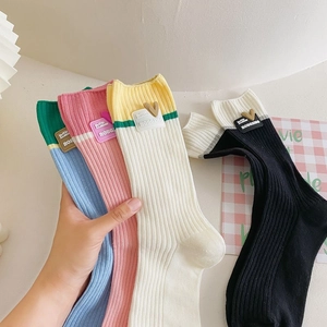 Macro view of ribbed cotton socks with contrast heart patches and color blocking