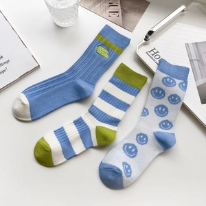Detailed set of blue crew socks featuring stripes, smile prints and ribbed cotton textures