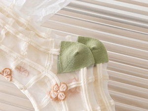 Close-up of sheer mesh socks with floral embroidery and green color block heel