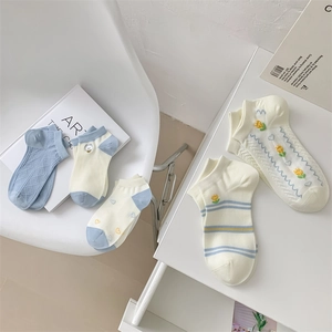 Flat lay of blue and white cotton socks featuring tulip and heart embroidery patterns