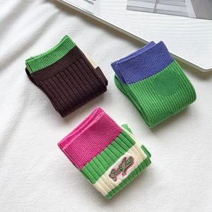 Detailed knit texture and Good Luck embroidery on these colorful mid-calf cotton socks