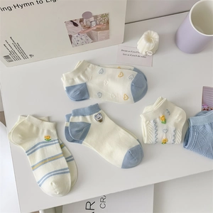 Flat lay of blue and white cotton ankle socks with embroidery and floral patterns