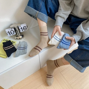 Detail showing knit striped crew socks for men in various colors with elastic cuffs