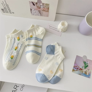 Detailed view of white cotton ankle socks featuring cute tulip and blue heart embroidery