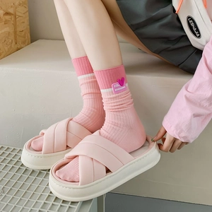 Pink platform slides and heart-patterned socks ensemble worn on minimalist steps