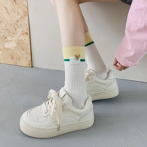 Detailed shot of white ribbed mid-calf socks with heart patch and yellow green color blocks