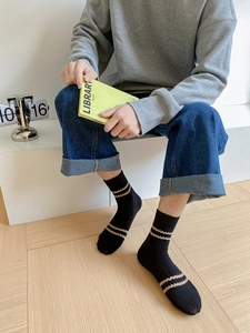 Detail of vintage-style black mid-calf socks with khaki wavy stripes on cotton fabric