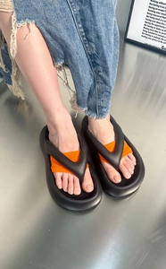 Detail of platform flip-flop with black foam base and orange elastic fabric arch support