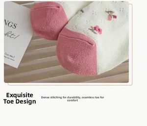Detail of floral embroidery on off-white mesh socks with reinforced pink toe stitching
