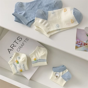 Close-up of blue cotton socks with cute bear labels and floral patterns for women