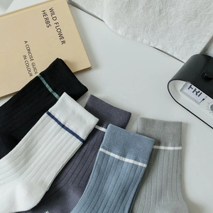 Detail of five-color striped cotton mid-calf socks with ribbed texture in a minimalist setting