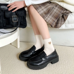 Women's black platform leather loafers with round toe and U-stitch on feet