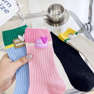 Colorful ribbed crew socks with heart patch detail shown in four vibrant colorways