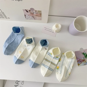Macro view of five-pack blue cotton socks with cute animal embroidery and floral patterns