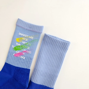 Detailed view of color-block crew socks with ribbed texture and graffiti pattern