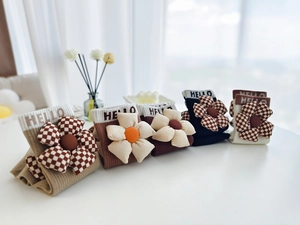 Détail de chaussettes en coton avec texte 'HELLO' tricoté et fleurs 3D rembourrées
