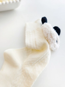 Detail shot of cream knit socks featuring cute 3D plush animal doll and ribbed texture