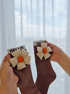Gros plan de chaussettes en coton marron avec fleur 3D et bord à rayures Hello