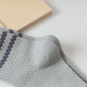 Macro shot of grey cotton knit socks featuring breathable mesh and wavy texture