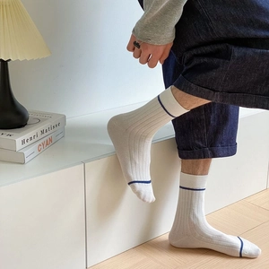 Detailed view of white cotton mid-calf socks with blue stripes and ribbed texture