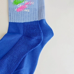 Detail of blue mid-calf cotton socks featuring embroidery and thick terry texture