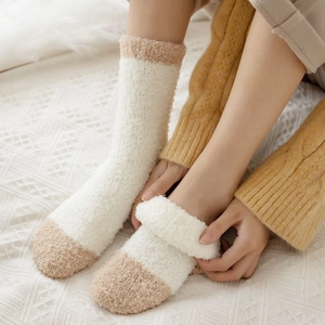 Close-up of thick coral fleece winter socks in cream and brown patchwork style