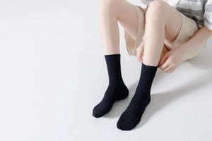Detailed knit texture of solid black cotton crew socks with elastic ribbed cuffs