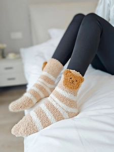 Gros plan de chaussettes en polaire corail rayées avec décoration ours en 3D