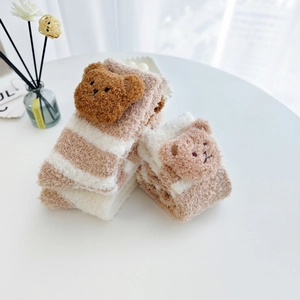 Vue détaillée de chaussettes en polaire corail à rayures avec décoration ours en peluche