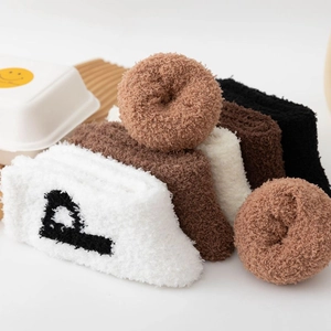 Thick coral fleece socks in earthy tones displayed in a cozy minimalist home setting