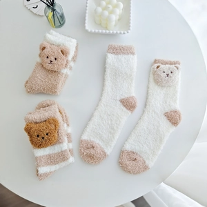 Gros plan de chaussettes épaisses en polaire corail avec motifs oursons 3D d'hiver