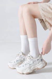 Detail of off-white chunky sneakers with white crew socks for a clean minimalist style
