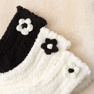 Detailed texture of thick coral fleece winter socks with decorative knit flower accents