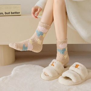 Close-up of thick coral fleece socks and plush slippers in a cozy home setting