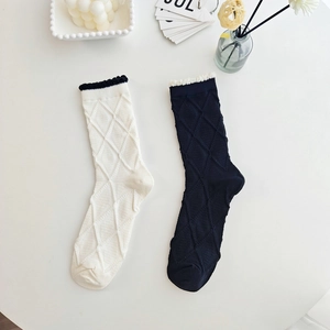 Close-up of crew socks featuring 3D diamond knit pattern and scalloped wave cuffs