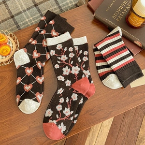 Detail of vintage knit crew socks featuring heart argyle, floral patterns, and retro stripes