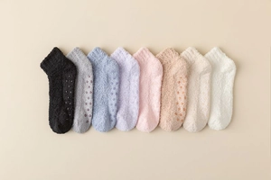 Close-up of non-slip silicone grips on warm coral fleece socks in multiple colors