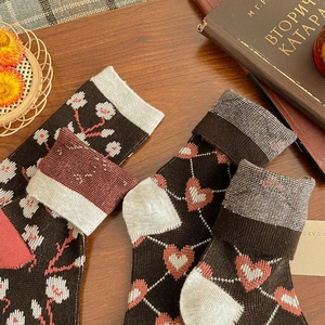 Detail of vintage floral knit crew socks for women on a cozy rustic wooden tabletop