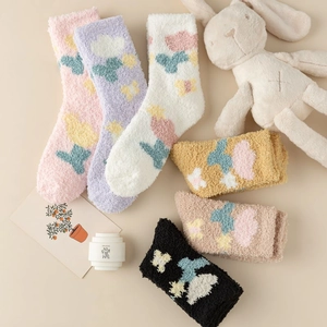 Detail of coral fleece socks featuring colorful floral and butterfly jacquard patterns
