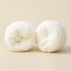 Close-up of rolled white coral fleece warm socks showing soft fluffy texture