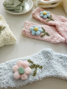 Detailaufnahme dicker Korallenvlies-Socken mit 3D-Blumen und weicher Plüschtextur