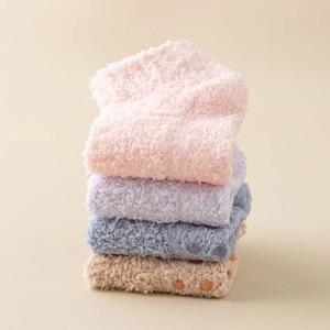 Detailed view of non-slip silicone grips on warm coral fleece thermal socks for women