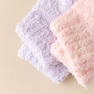 Close-up of thick coral fleece texture on pink and purple thermal winter socks