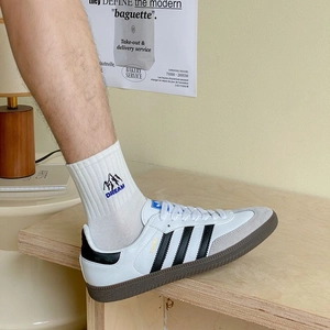 Detail of white cotton crew socks with embroidered peak icon and Dream text on ankle
