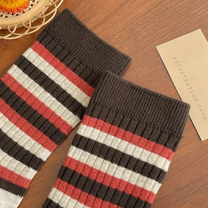 Close-up of retro striped knit cotton socks with ribbed cuffs on a vintage wooden surface