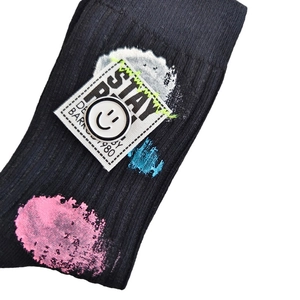 Y2K street style black ribbed mid-tube socks with graffiti paint and STAY badge