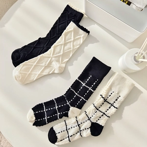 Set of four black and white cotton socks featuring stylish diamond and grid patterns